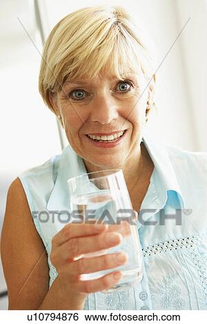 Stock Photograph - Middle Aged Woman Drinking A Glass Of Water. Fotosearch
