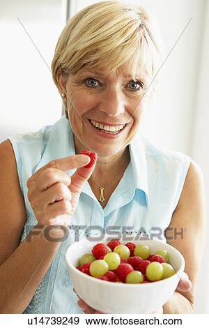 Middle Aged Woman Eating A Bowl Of Fruit View Large Photo Image Stock Photo - Middle Aged Woman Eating A Bowl Of Fruit. Fotosearch