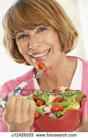 Middle Aged Woman Eating A Fresh Green Salad View Large Photo Image Stock Image - Middle Aged Woman Eating A Fresh Green Salad. Fotosearch