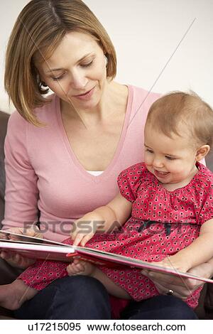 Stock Photography - Mother And Baby Daughter Reading Book. Fotosearch