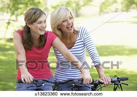 Mother And Daughter Cycling Through A Park View Large Photo Image Stock Image - Mother And Daughter Cycling Through A Park. Fotosearch