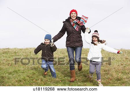 Stock Photo - Mother And Her Children Running In The Park. Fotosearch