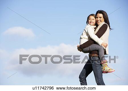 Mother Carrying Her Daughter View Large Photo Image Stock Photograph - Mother Carrying Her Daughter. Fotosearch