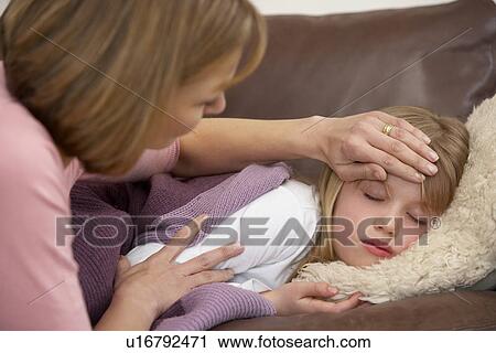 Stock Image - Mother Taking Temperature Of Sick Daughter. Fotosearch