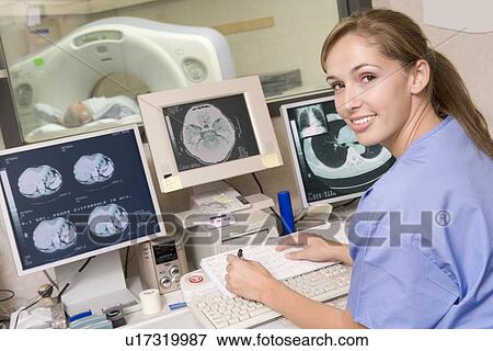 Stock Photo - Nurse Monitoring Patient Having A Computerized Axial Tomography (CAT) Scan. Fotosearch