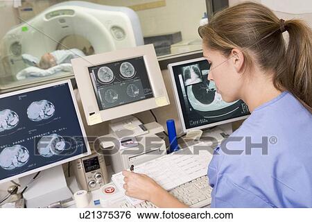 Stock Photograph - Nurse Monitoring Patient Having A Computerized Axial Tomography (CAT) Scan. Fotosearch
