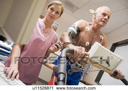 Stock Image - Nurse With Patient During Health Check. Fotosearch