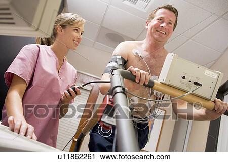 Stock Image - Nurse With Patient During Health Check. Fotosearch