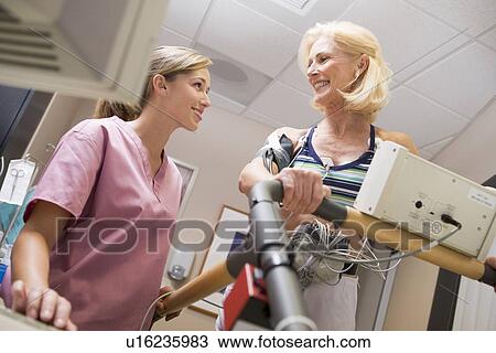 Stock Image - Nurse With Patient During Health Check. Fotosearch