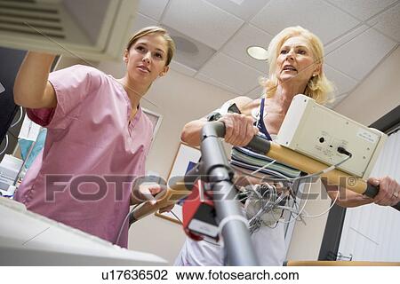 Stock Image - Nurse With Patient During Health Check. Fotosearch
