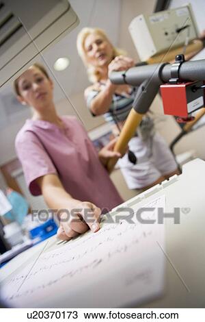 Stock Image - Nurse With Patient During Health Check. Fotosearch