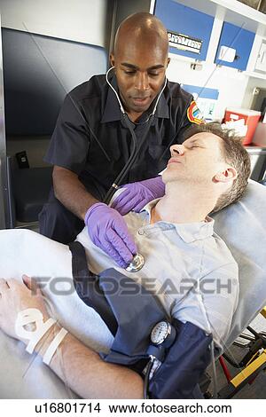 Paramedic attending to patient in ambulance View Large Photo Image Picture - Paramedic attending to patient in ambulance. Fotosearch