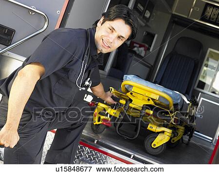 Stock Photo - Paramedic removing empty gurney from ambulance. Fotosearch