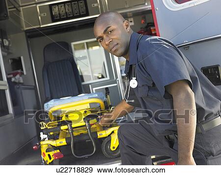 Stock Photo - Paramedic removing empty gurney from ambulance. Fotosearch