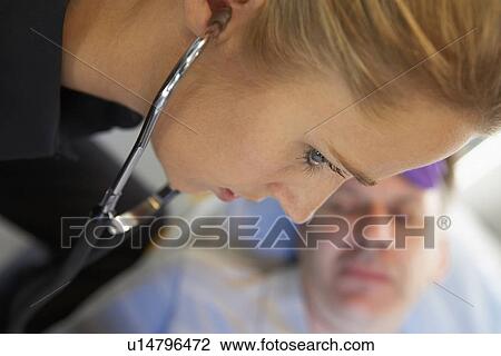 Paramedic using stethoscope on patient in ambulance View Large Photo Image Stock Image - Paramedic using stethoscope on patient in ambulance. Fotosearch