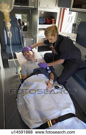 Stock Photo - Paramedic with patient in ambulance. Fotosearch