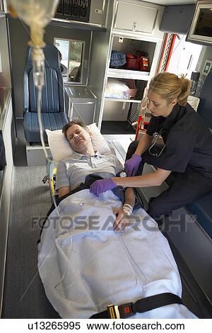 Stock Photography - Paramedic with patient in ambulance. Fotosearch