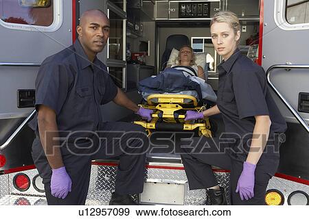 Stock Photo - Paramedics preparing to unload patient from ambulance. Fotosearch