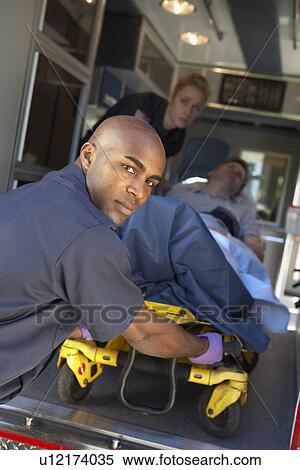 Paramedics preparing to unload patient on gurney View Large Photo Image Stock Photography - Paramedics preparing to unload patient on gurney. Fotosearch