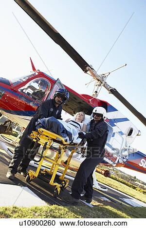 Stock Image - Paramedics unloading patient from Medevac. Fotosearch