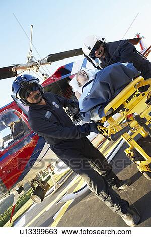 Stock Image - Paramedics unloading patient from Medevac. Fotosearch