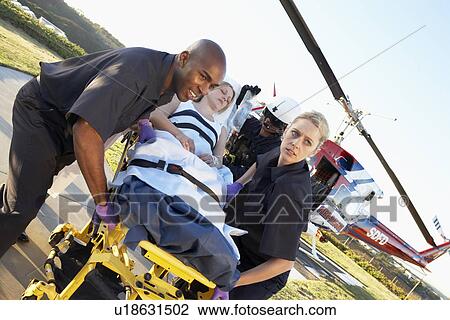 Stock Image - Paramedics unloading patient from Medevac. Fotosearch