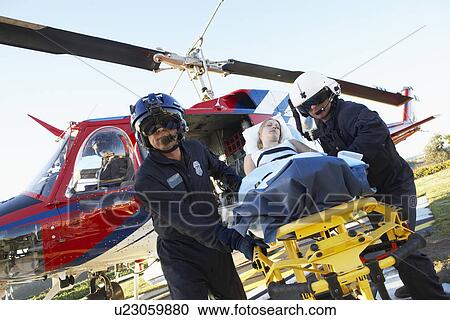 Stock Image - Paramedics unloading patient from Medevac. Fotosearch