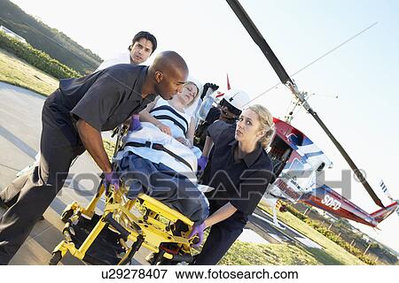 Stock Photo - Paramedics unloading patient from Medevac. Fotosearch