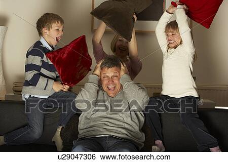 Stock Photograph - Parents And Two Children In Pillow Fight. Fotosearch