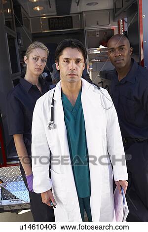 Stock Photograph - Portrait of doctor with two paramedics in front of ambulance. Fotosearch