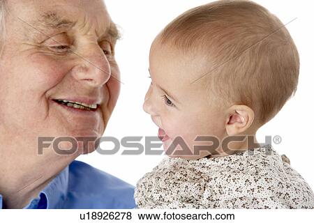 Stock Photo - Portrait of grandfather and granddaughter, smiling at each other. Fotosearch