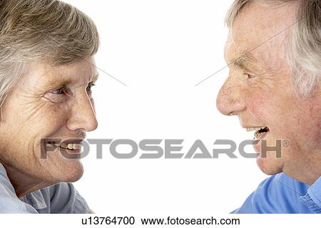Stock Image - Portrait of senior couple smiling at each other. Fotosearch