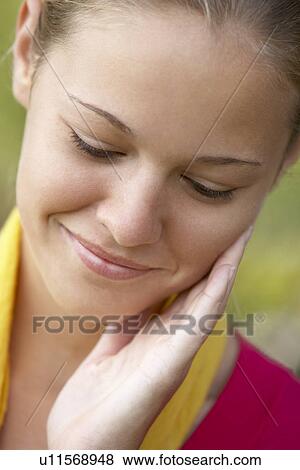 Stock Photo - Portrait Of Teenage Girl Resting Head In Hands And Smiling. Fotosearch