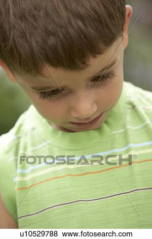 Stock Photo - Portrait Of Young Boy Looking Down. Fotosearch