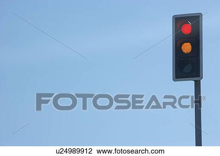 Stock Image - Red Traffic Light Set Against A Blue Sky. Fotosearch
