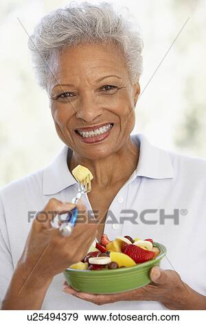 Stock Photo - Senior Adult Eating A Fresh Fruit Salad. Fotosearch