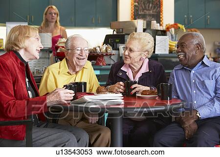 Stock Image - Senior adults having morning tea together. Fotosearch