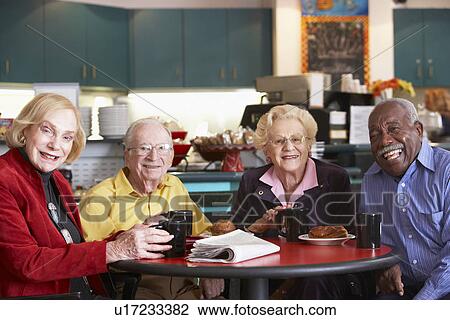 Stock Image - Senior adults having morning tea together. Fotosearch