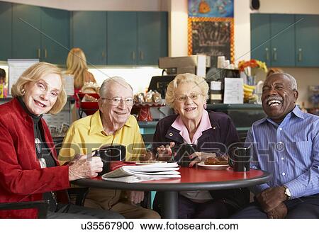 Stock Image - Senior adults having morning tea together. Fotosearch