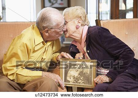Senior couple holding wedding photo View Large Photo Image Picture - Senior couple holding wedding photo. Fotosearch