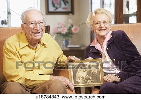 Senior couple holding wedding photo View Large Photo Image Stock Image - Senior couple holding wedding photo. Fotosearch