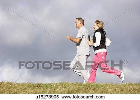 Stock Photography - Senior Couple Jogging In The Park. Fotosearch