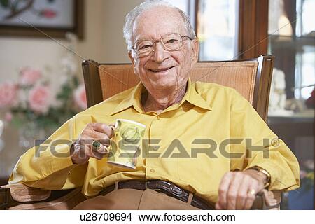 Picture - Senior man drinking hot beverage. Fotosearch