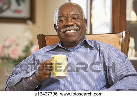 Stock Photograph - Senior man drinking hot beverage. Fotosearch
