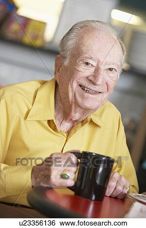 Stock Photograph - Senior man drinking hot beverage. Fotosearch
