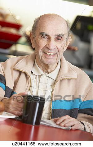 Stock Photograph - Senior man drinking hot beverage. Fotosearch