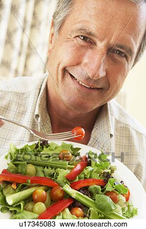 Stock Image - Senior Man Eating A Healthy Salad. Fotosearch