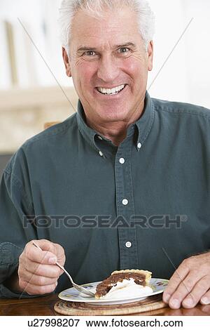Stock Photo - Senior Man Eating Chocolate Cake. Fotosearch