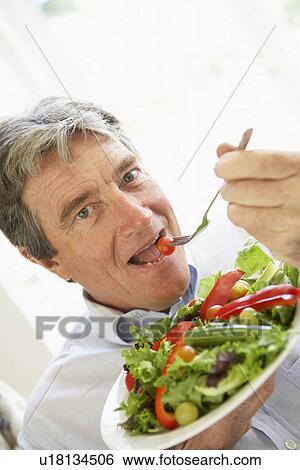 Stock Photograph - Senior Man Eating Salad. Fotosearch