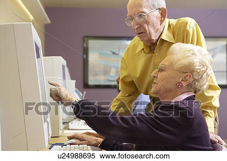 Senior man helping senior woman to use computer View Large Photo Image Stock Photography - Senior man helping senior woman to use computer. Fotosearch